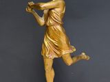 a gold statue of a woman holding a bird on a marble base
