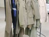 a lot of coats hanging on a rack in a room