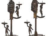three bronze figurines of a man and a woman with a skull on their head