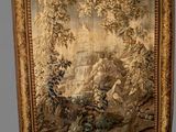 an antique tapestry hanging on a wall with a painting of a landscape