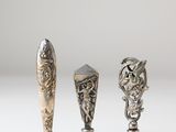 three silver spoons sitting next to each other on top of a table