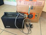 a black toaster sitting on the floor next to a box