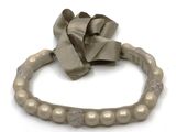 un bracelet orné d'un nœud, posé sur un fond blanc