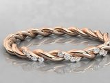 a rose gold braid ring with diamonds on a reflective surface