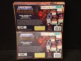two boxes of masters of the universe card game on a black background