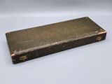 an old black book sitting on top of a white table