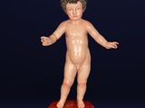 an image of a small statue of a boy standing on top of a red box