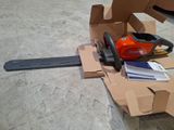 a chainsaw that is sitting on the ground next to a box