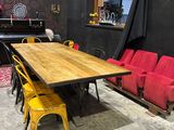 tables and chairs in a room with a piano in the background