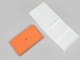 an orange and white box with a piece of paper next to it