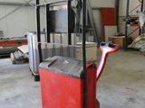 un chariot élévateur rouge garé dans un entrepôt