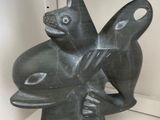 a statue of a fish on a shelf in a glass case
