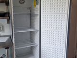 an open refrigerator in a kitchen with a tiled floor