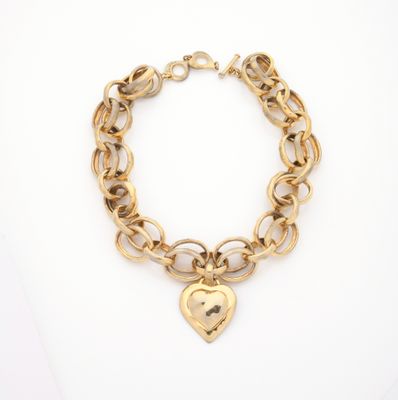 a gold bracelet with a heart charm on it