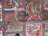 a person standing in front of a patchwork rug on the floor