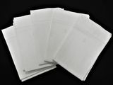 une pile d'enveloppes blanches posée sur une surface noire