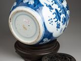 a blue and white vase sitting on top of a wooden stand