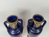 two blue vases sitting next to each other on a table