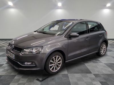 La Volkswagen Polo grise est garée dans une pièce au sol carrelé en damier.