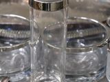 a silver tray with rings and a glass on it