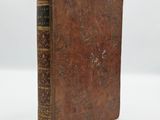 an old book sitting on top of a white surface