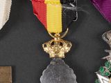 three medals and a cross on a black surface