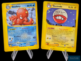 two pokemon cards that are on display on a table