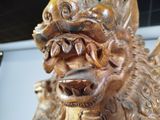a wooden statue of a lion with a large mouth