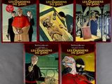 four books on a table with a picture of a man in a red robe