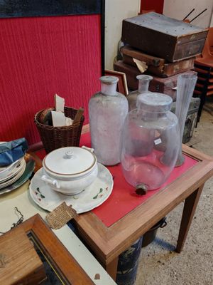 une table sur laquelle sont posées plusieurs bouteilles en verre et des assiettes