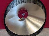 a large metal disc with a red clock on it
