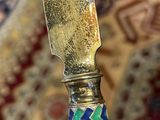 someone is holding a knife in their hand on a rug