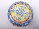 yellow and blue vase with floral design on it on a white surface