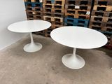 two white tables sitting next to each other in a room