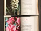 an open book with a picture of a plant and flowers on it