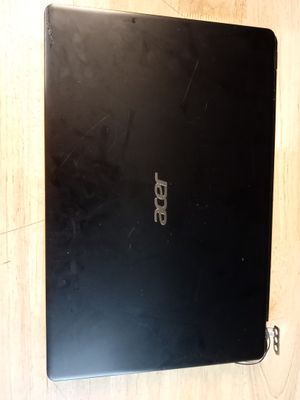 un ordinateur portable ouvert posé sur une table en bois