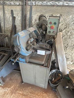 une machine posée par terre à côté d'un tas de bois