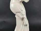 une image représentant une statue d'une femme avec un oiseau sur l'épaule