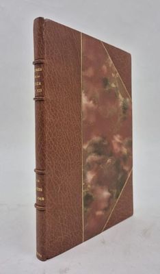 an old book with a brown cover sitting on a white surface