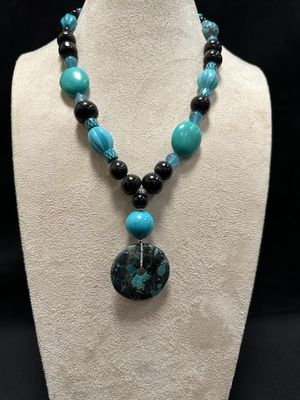 a necklace with a blue and black bead and a black pendant