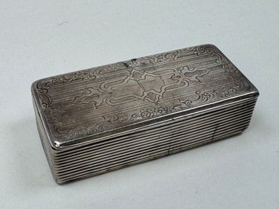 une boîte ancienne en argent posée sur une table blanche, sur fond blanc