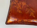 a brown leather box with a floral design on it