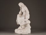 statue of a woman sitting on a rock with a bird in her hand