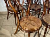 six wooden chairs are lined up in a row on a tiled floor