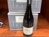 une bouteille de vin posée sur une étagère à côté de deux boîtes