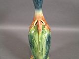 a small vase with a bird on it on a table