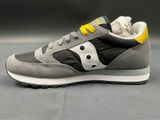 grey and yellow sneakers with a black and white logo on the side