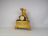 a gold clock with a statue on top of it