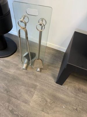 a glass table with a pair of tongs on top of it