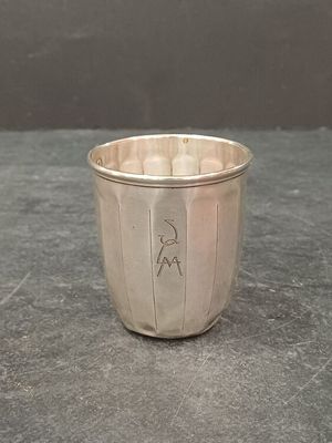 une coupe en argent posée sur une table, sur fond noir